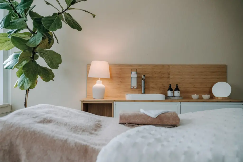 Detailreiche Innenaufnahme mit Behandlungsliege, Lampe und Waschbereich im Skincare Studio Chemnitz