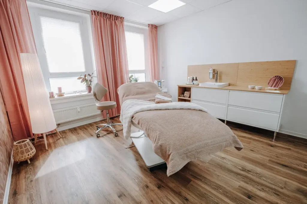 Detailreiche Innenaufnahme mit Behandlungsliege, Lampe und Waschbereich im Skincare Studio Chemnitz