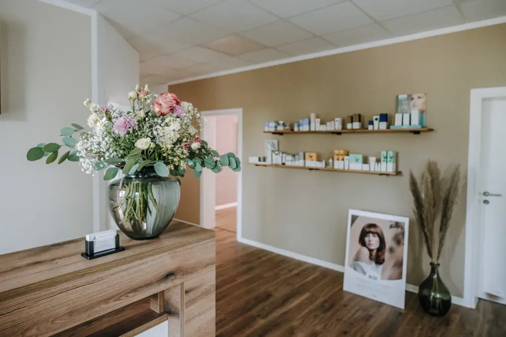 Empfangsbereich mit Tresen, Produktregalen und warmer Studioatmosphäre bei Alexandra Linsner Skincare