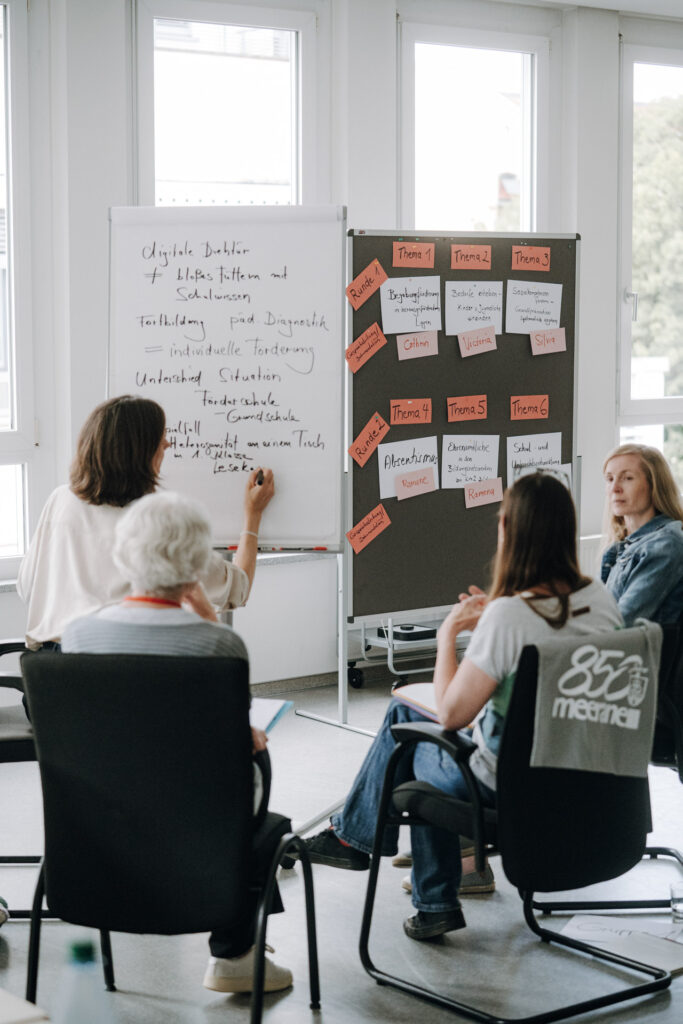Teilnehmende im Gespräch in einer kleinen Workshop-Gruppe beim Netzwerktreffen in Meerane