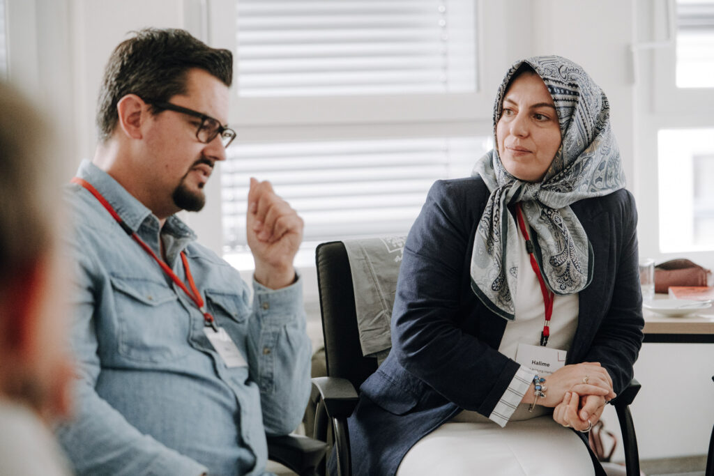 Teilnehmerin schreibt an einer Moderationswand beim Workshop des Bundesnetzwerktreffens