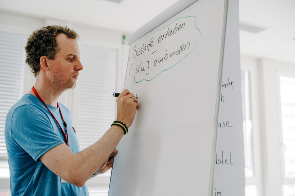 Teilnehmer ergänzt Themenkarten bei einem Workshop von Ein Quadratkilometer Bildung in Meerane